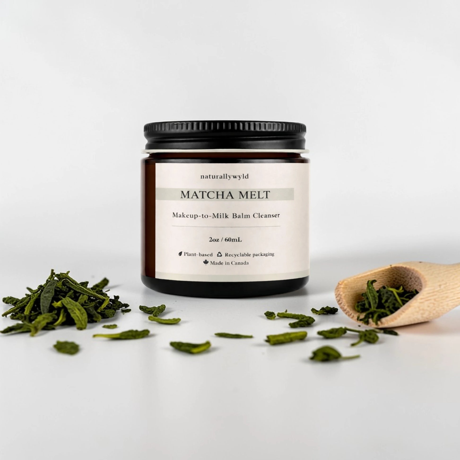 Matcha Melt balm cleanser jar with matcha leaves on a white background