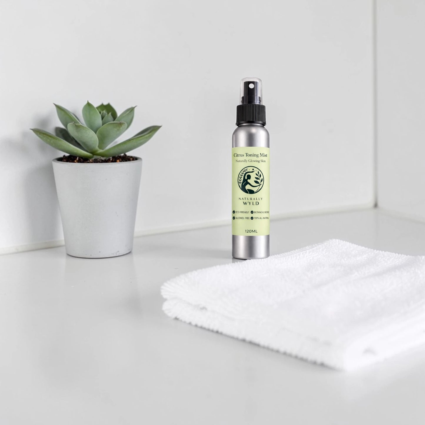 Bottle of natural product with a plant and towel on a white surface