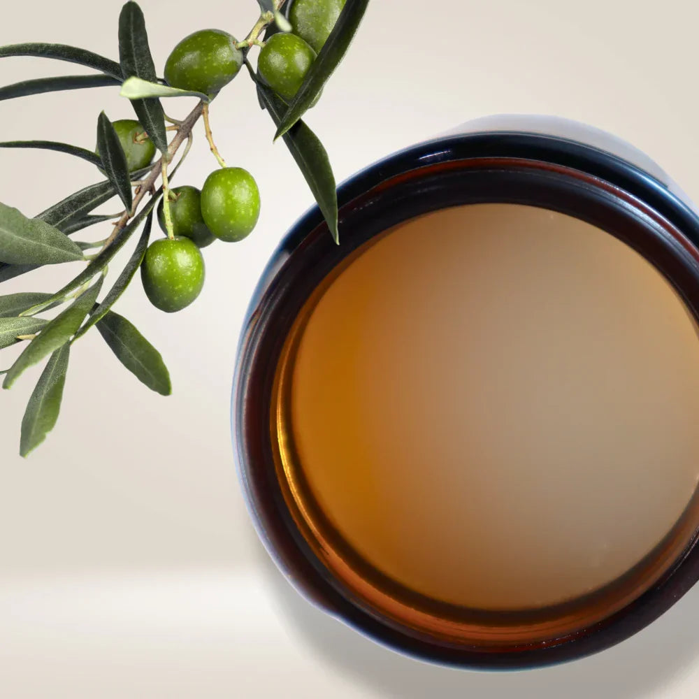 Open amber jar of Naturally Wyld Ozonated Olive Oil + Neroli showing smooth, creamy balm texture. Cold-pressed, 100% all-natural olive oil infused with neroli for skin rejuvenation. Ideal for face and body hydration.