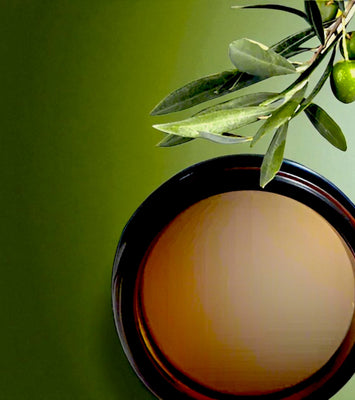 Jar of Ozonated olive oil with an olive branch on a green background