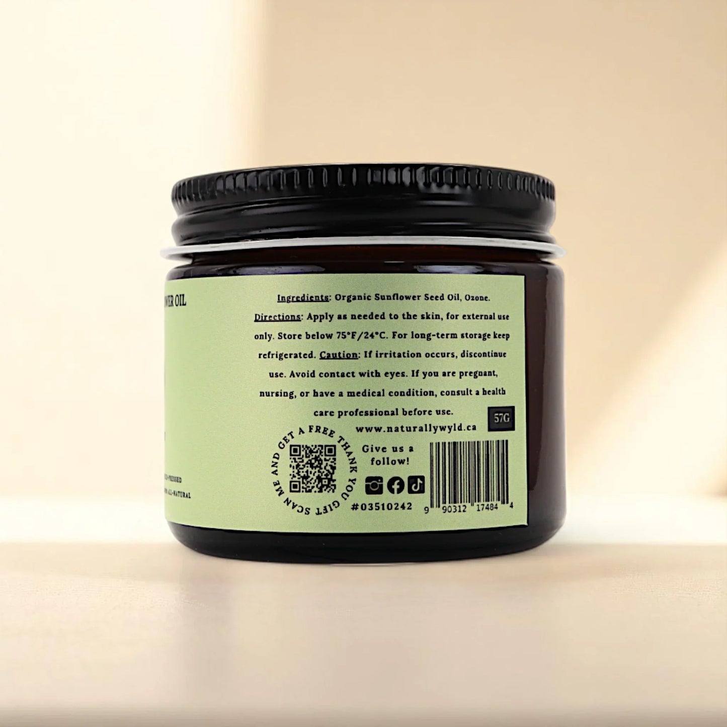 Back label of Naturally Wyld ozonated sunflower seed oil jar, featuring full ingredient list (organic sunflower seed oil, ozone), external use guidance, and storage recommendations; a clean-label ozone oil favored for minimalist routines and plant-based topical care.