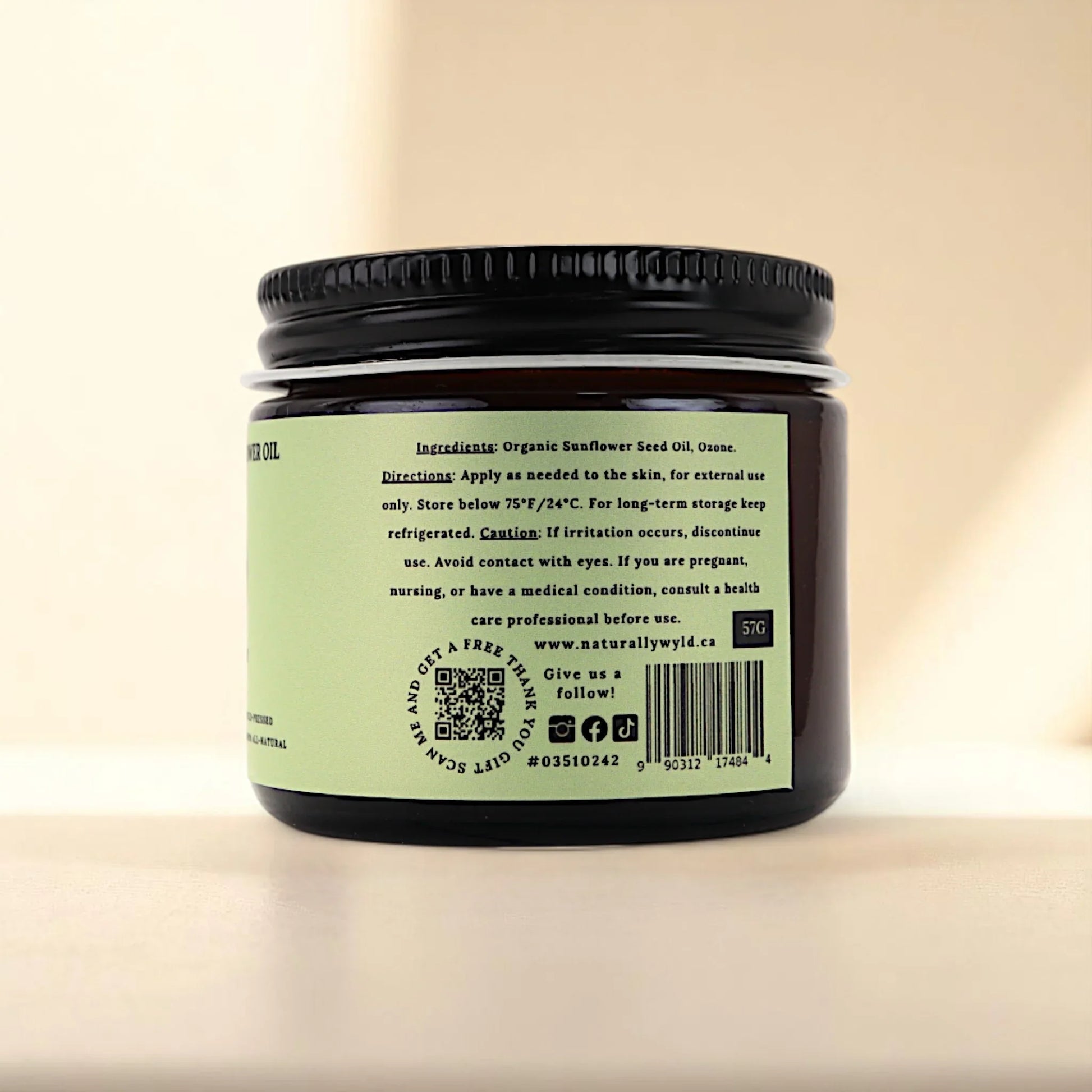 Back label of Naturally Wyld ozonated sunflower seed oil jar, featuring full ingredient list (organic sunflower seed oil, ozone), external use guidance, and storage recommendations; a clean-label ozone oil favored for minimalist routines and plant-based topical care.